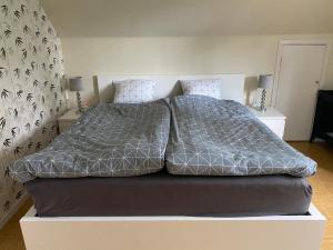 un letto con piumone grigio in una camera da letto di Villa Movägen • Fast Free Wifi • AC • 10 min from lake a Mörlunda