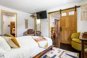 um quarto com uma cama branca e uma televisão em The Herwood Inn em Woodstock