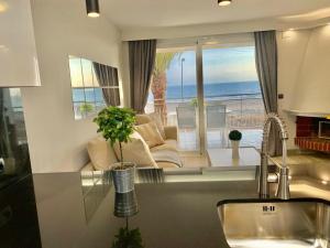 a kitchen with a living room with a view of the ocean at Formentor in Castelldefels