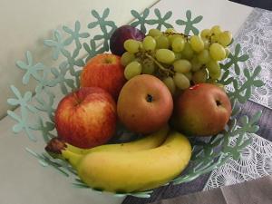 un bol de fruits avec des pommes, des bananes et des raisins dans l'établissement Ferienwohnung ODIN, FREYA & THOR, à Thale