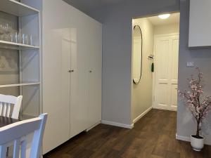 pasillo con armarios blancos, mesa y sillas en Central Studio Apartment, en Stavanger