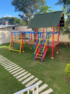 un parque infantil con un colorido equipo de juegos en un patio en Condomínio Recanto dos Dourados - Casa de Temporada en Três Marias