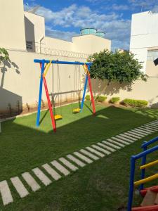 a swing set on a lawn in a yard at Condomínio Recanto dos Dourados in Três Marias