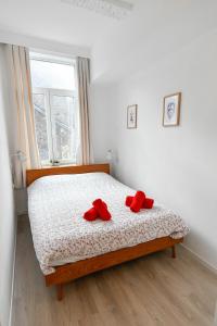 Un dormitorio con una cama con zapatos rojos. en Les Cerisiers - Appartement Cosy au Centre de Namur, en Namur