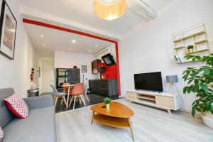 a living room with a couch and a tv and a table at Les Cerisiers - Appartement Cosy au Centre de Namur in Namur