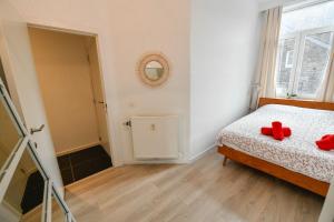 Un dormitorio con una cama con dos ositos de peluche rojos. en Les Cerisiers - Appartement Cosy au Centre de Namur en Namur