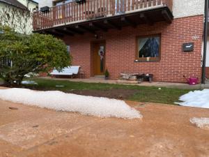 a pile of snow on the ground in front of a house at Apartmán pod lesem in Svoboda nad Úpou