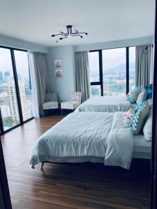 a bedroom with two beds and a large window at SUNRISE Gurney Seaview Luxury Duplex in George Town