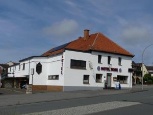 a white building on the corner of a street at Hotel Rose in Warburg