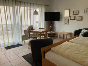 un soggiorno con letto e tavolo con sedia di Landhaus-Apartments a Wattenheim
