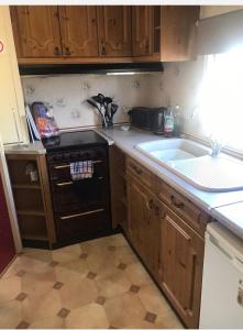a small kitchen with a sink and a stove at Heacham South Beach static caravan in Heacham
