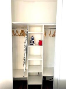 a closet with white shelves and hangers at LE CARDINAL, appartement avec parking privé, gare, centre ville, in Annecy