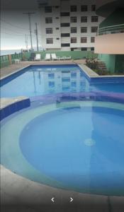 a large swimming pool in front of a building at Suites Marbensa, Malecón de Atacames in Atacames