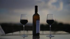 Una botella de vino y dos copas en una mesa. en Golden Cave Suites, en Ürgüp