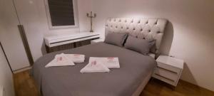 een slaapkamer met een groot bed en handdoeken bij Luxury Apartment IVA II in Skopje