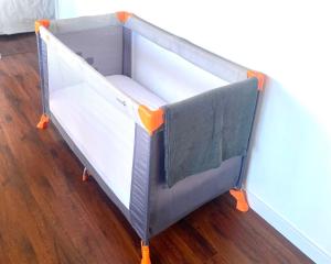 a bed frame with orange wheels on a wooden floor at LE CARDINAL, appartement avec parking privé, gare, centre ville, in Annecy