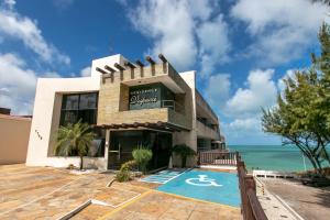 a building with a swimming pool next to the ocean at Residence Vespucci in Natal