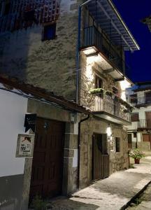 Edificio de piedra con puerta y balcón en LA CASA REBONITA en Candelario