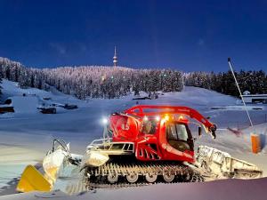 a red snowmobile on a snow covered slope at Luxury Aparthotel STUDENETS in Pamporovo