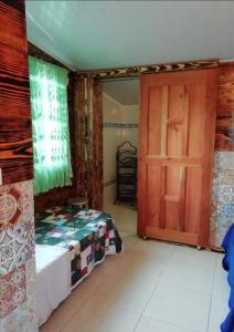 Schlafzimmer mit einem Bett und einer Holztür in der Unterkunft Lita's Place in Cordillera Arriba