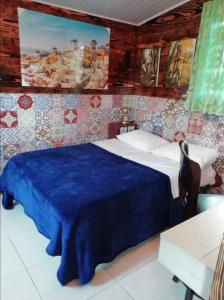 um quarto com uma cama com um cobertor azul em Lita's Place em Cordillera Arriba