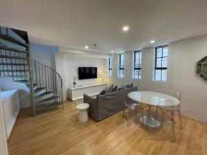 a living room with a couch and a glass table at Modern 2 Bedroom Warehouse Conversion in Sydney