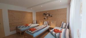 twee bedden in een kamer met houten wanden bij Silberblick Ferienwohnungen - aussergewöhnlich & familienfreundlich in Grächen