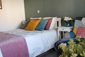 a bedroom with a bed with colorful pillows on it at Pretty and quiet studio, with wifi and parking in Limassol