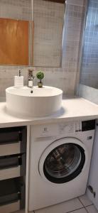 a bathroom with a washing machine and a sink at Pretty and quiet studio, with wifi and parking in Limassol