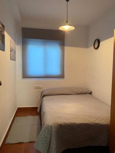 Schlafzimmer mit einem Bett vor einem Fenster in der Unterkunft Casa al sol in Adra