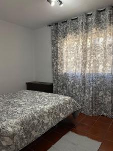 um quarto com uma cama e uma janela com uma cortina em Casa al sol em Adra