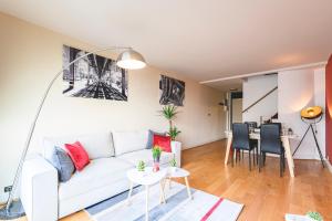 a living room with a white couch and a table at Appartement spacieux vue Cathédrale in Reims +11 photos