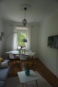 - un salon avec une table et des chaises blanches dans l'établissement Villa Hortensia, à Ljubljana