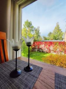 two white candles sitting on a table in front of a window at Polku Apartaments in Imatra