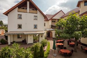 a view of the courtyard of a hotel with tables and chairs at Hotel Pfaffenhofen in Schwabenheim