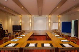 a large room with tables and chairs and a screen at Hotel Pfaffenhofen in Schwabenheim