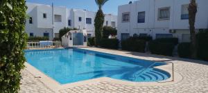 a large swimming pool in front of a building at Très beau studio avec piscine in Hammamet Sud