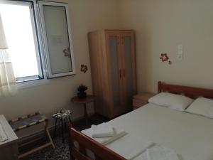 a small bedroom with a bed and a window at Aristoula House in Sivota