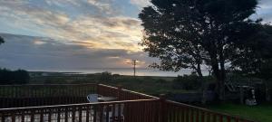 a deck with a wooden fence and a tree at Kilronan Holiday Homes in Kilronan