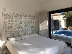 a bedroom with a large bed and a swimming pool at Monte dos Binos in Porto Covo