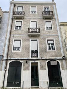 ein großes Backsteingebäude mit Fenstern und einem Balkon in der Unterkunft Manjericos House in Lissabon
