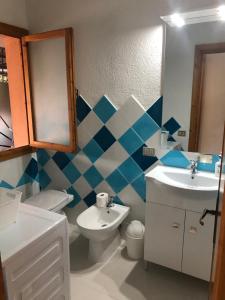 a bathroom with a sink and a toilet and a mirror at Centro e Cinta beach free bikes in San Teodoro
