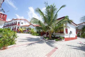 a palm tree in front of a building at Royal Elmount Hotel in Elmina
