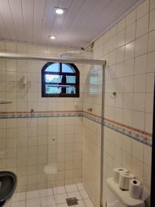a bathroom with a shower and a toilet and a window at Atelier Sylvio cavalheiro in Abraão