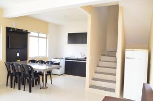 a kitchen and dining room with a table and chairs at Condomínio Recanto dos Dourados - Casa de Temporada in Três Marias