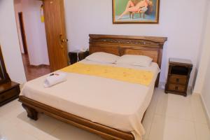 a bedroom with a large bed with a wooden headboard at Hotel La Makuira RB in Ríohacha