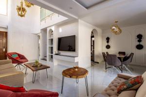 uma sala de estar com um sofá e uma televisão em Casa Amore Luxury 3 Bedroom Villa in Assagao North Goa em Vagator