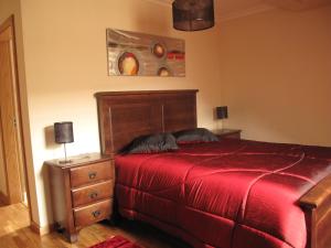 a bedroom with a bed and a dresser with a red blanket at Cantinho da Estrela in Seia