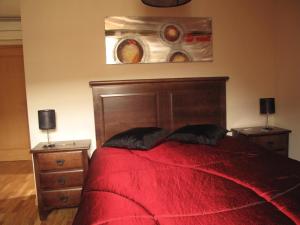 a bedroom with a red bed with two night stands at Cantinho da Estrela in Seia