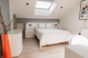 a bedroom with a white bed and a skylight at MK77 León - Atiko in León